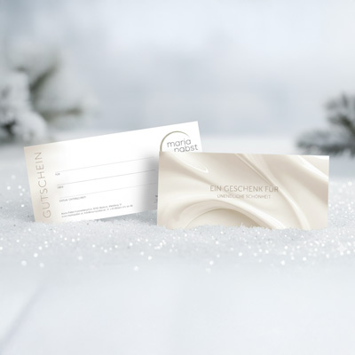 Vorder- und Rückseite eines eleganten Kosmetik-Gutscheins in winterlichem Schnee-Setting